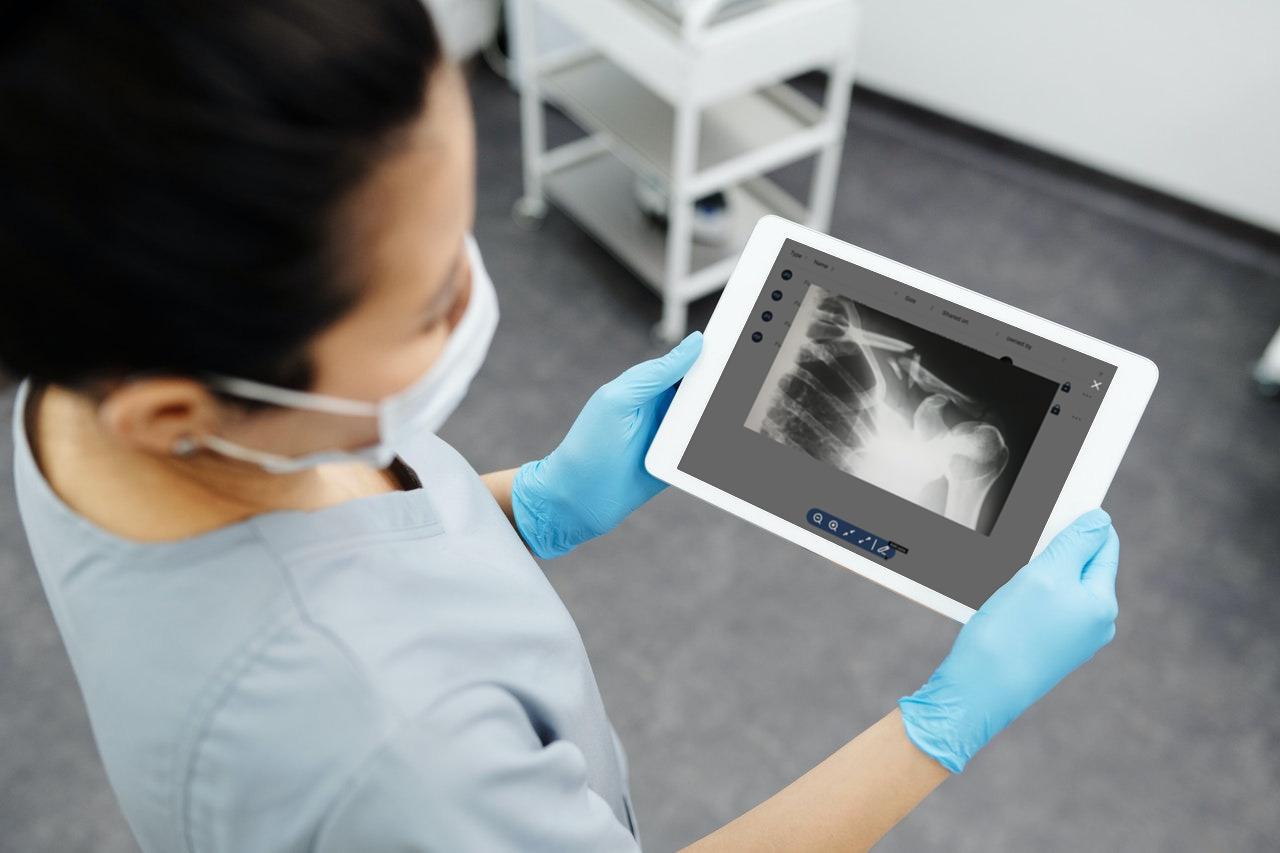 A healthcare professional reviewing an image on a tablet